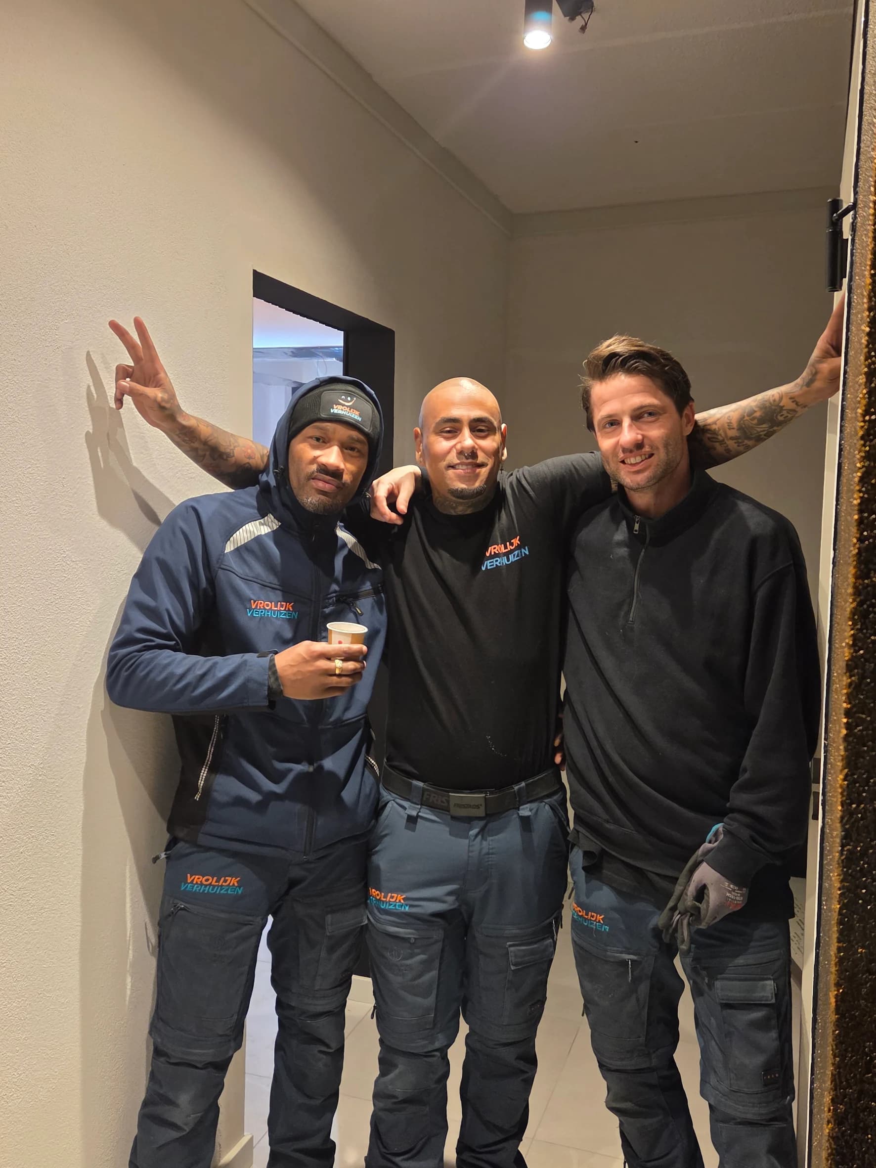 Three Vrolijk Verhuizen crew members in workwear ready for the jobs