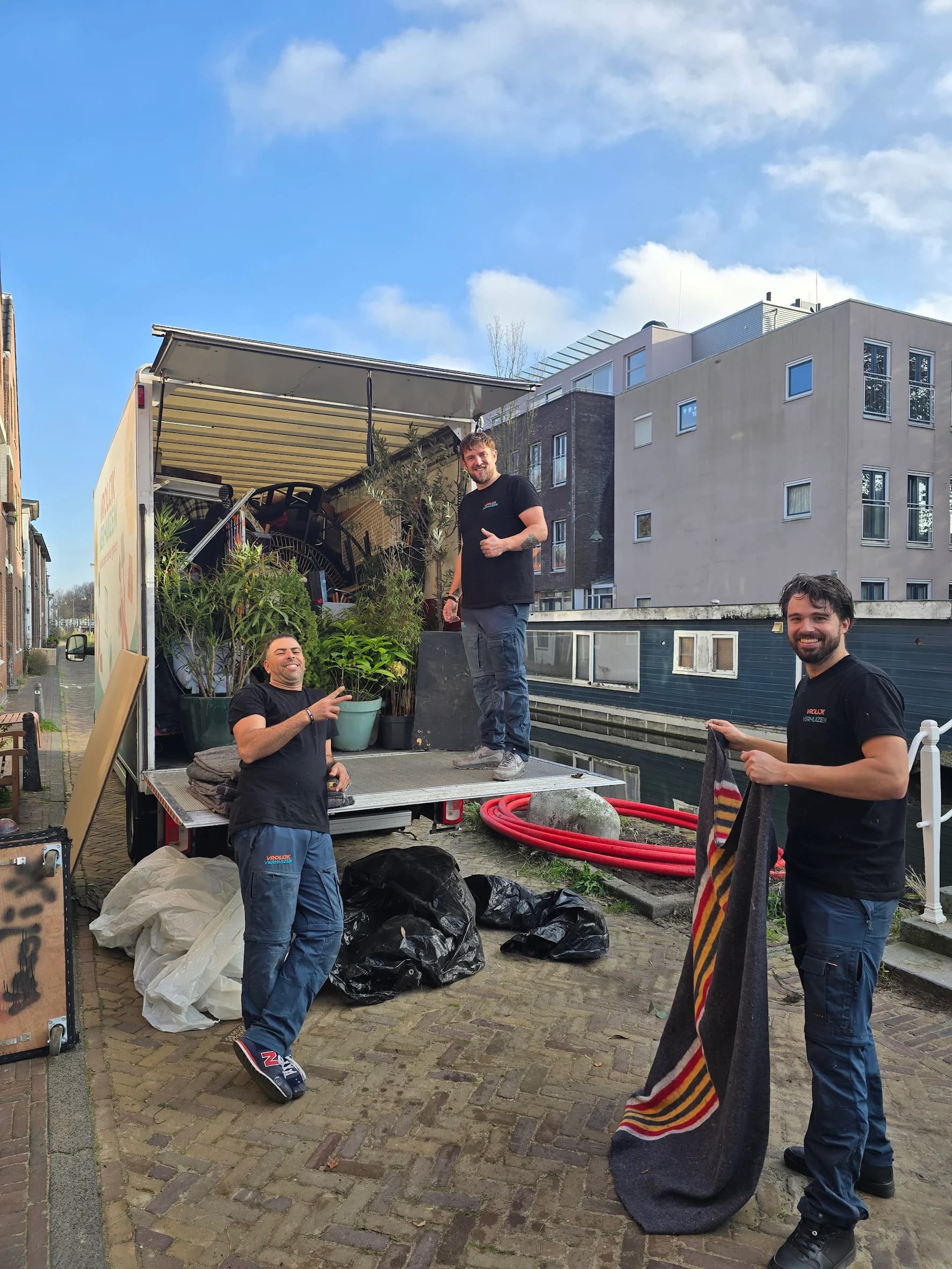 Vrolijk Verhuizen crew members handling a piece of furniture