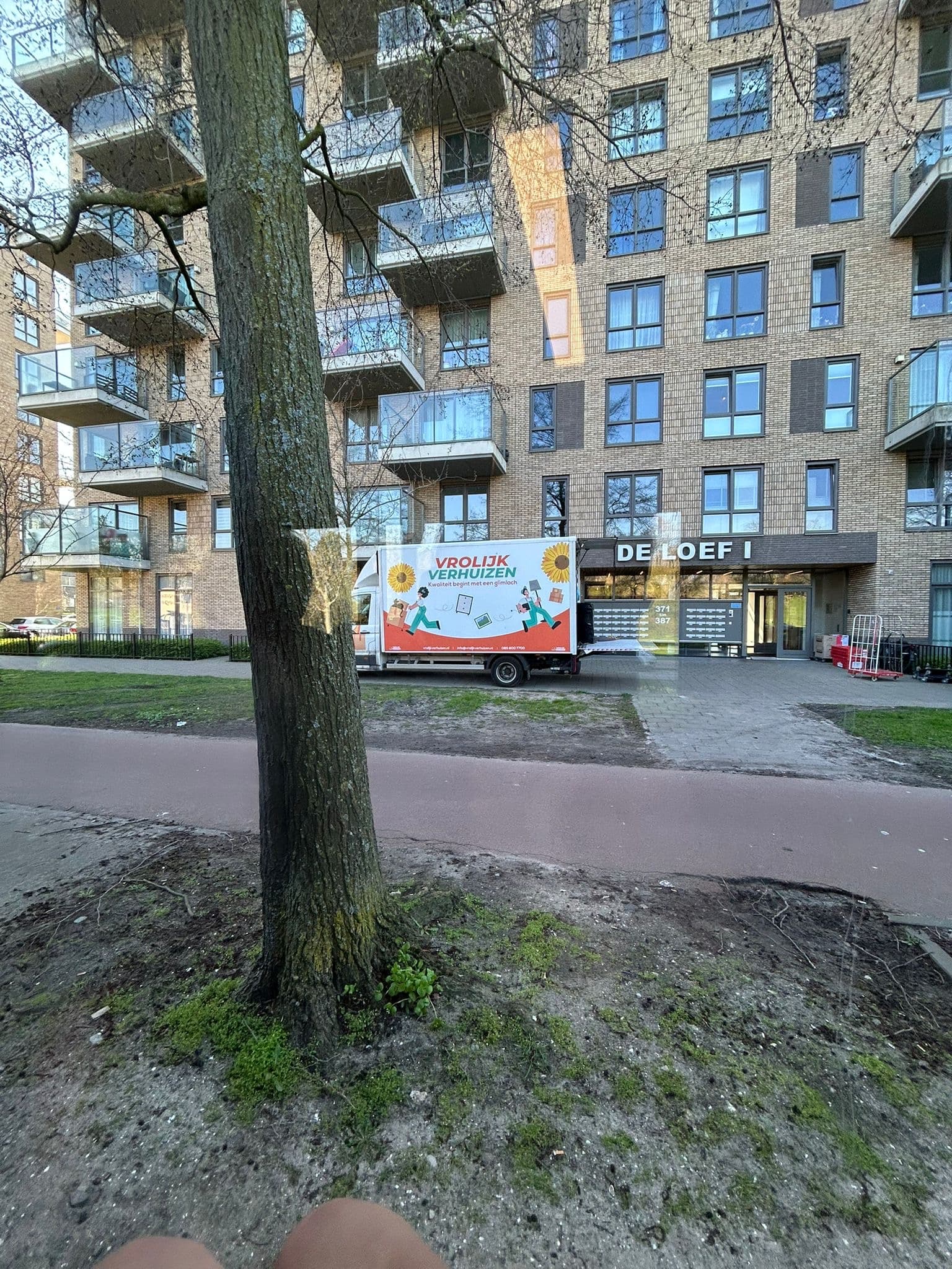 Vrolijk Verhuizen bus bij een nieuwbouwwoning in Almere