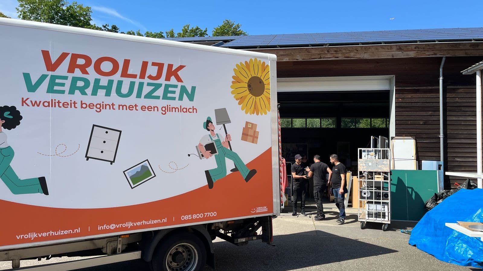 Vrolijk Verhuizen team werkt soepel samen bij de verhuiswagen