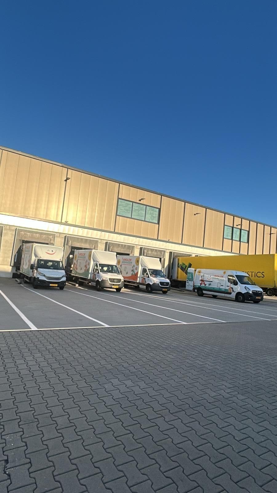 Vrolijk Verhuizen bussen op een rij bij de opslagloods