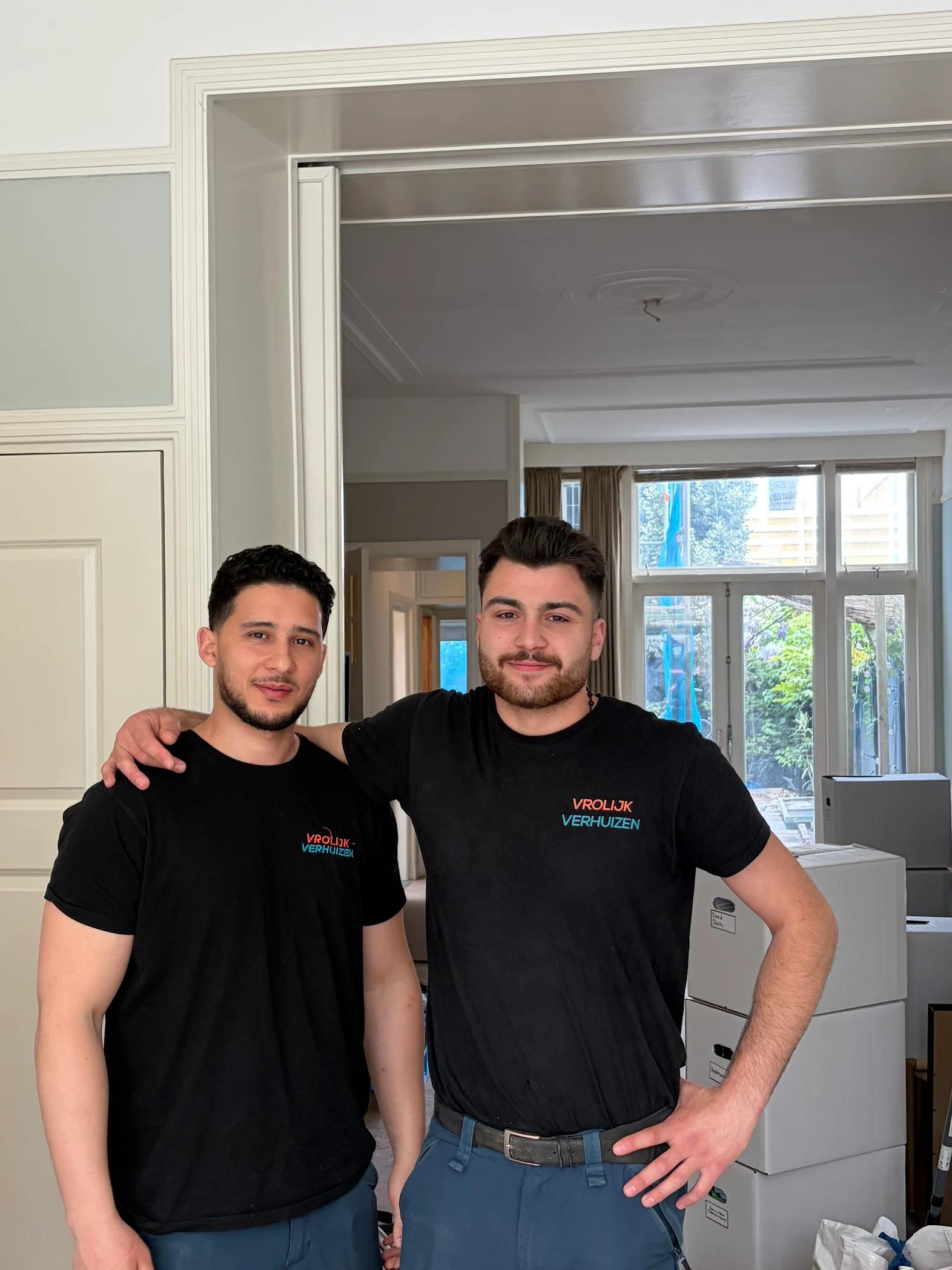 Twee Vrolijk Verhuizen crewleden met arm om de schouder tijdens een verhuizing